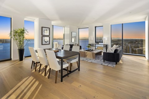 A dining room with a table and chairs and a view of the city.