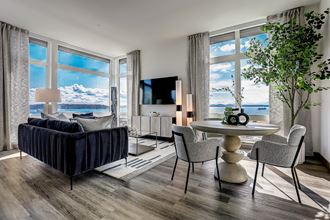 a living room with a large window and a view of a body of water