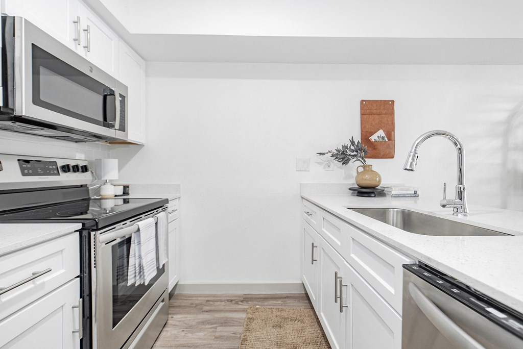 a modern kitchen with stainless steel appliances and white cabinets