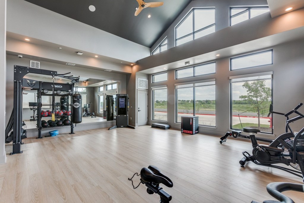 A spacious gym with a variety of equipment and a view of the outside.