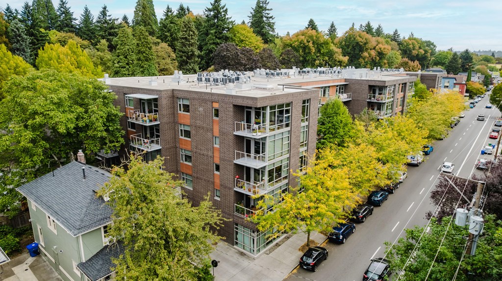 A large apartment building with a parking lot in front.