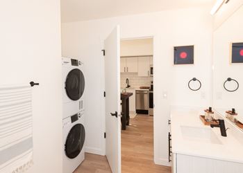 A white laundry room with a washer and dryer stacked on top of each other.