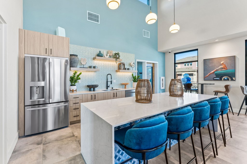 Marlette open kitchen with stainless steel appliances and blue chairs