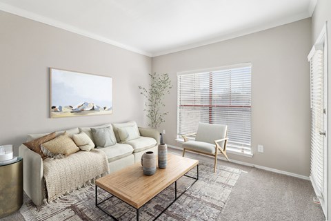 A living room with a couch, chair, and a painting on the wall.