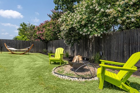 a backyard with a hammock and firepit