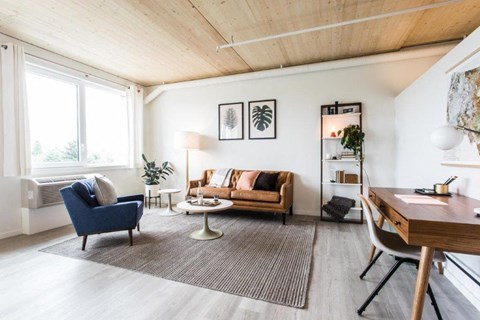 a living room with a couch and a chair and a desk