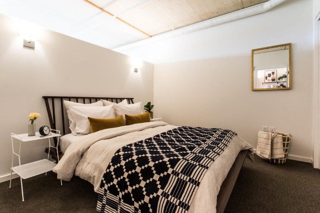 a bedroom with a bed and a black and white blanket
