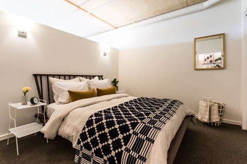 a bedroom with a bed and a black and white blanket