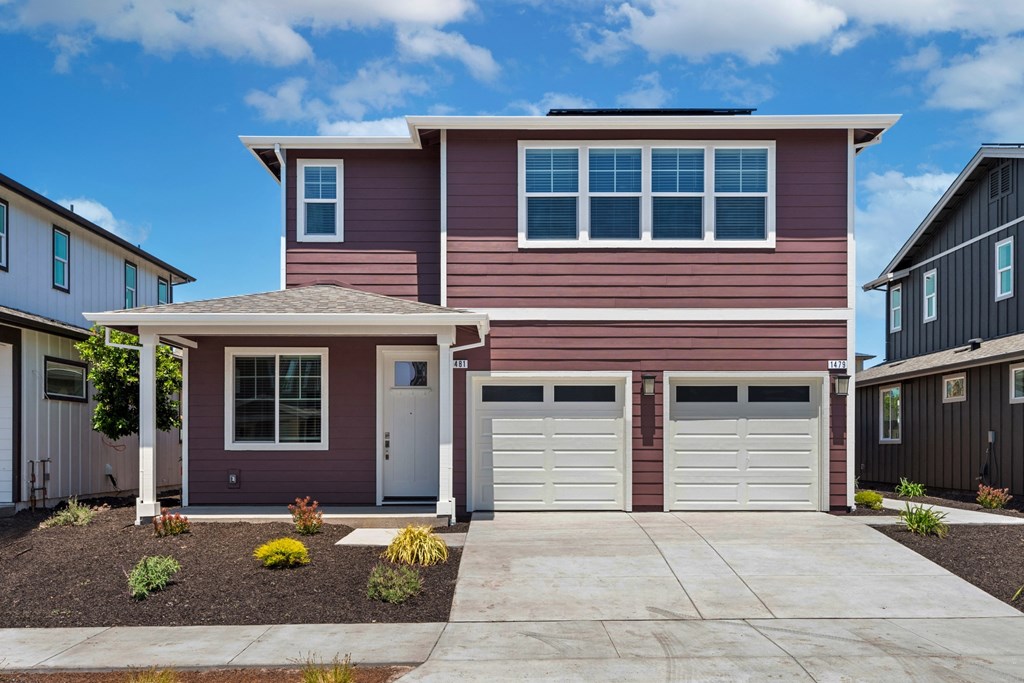 a red house with two garage doors and a driveway