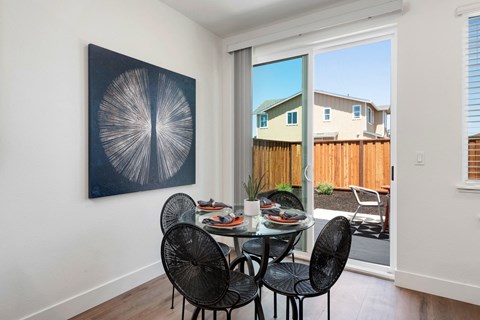 a dining room with a table and chairs and a sliding glass door