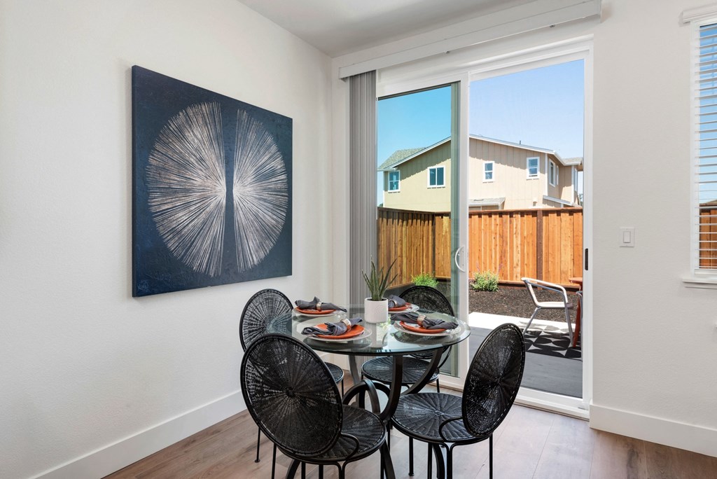 a dining room with a table and chairs and a sliding glass door