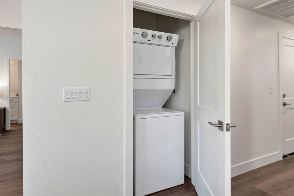 a white washer and dryer in a room with a door
