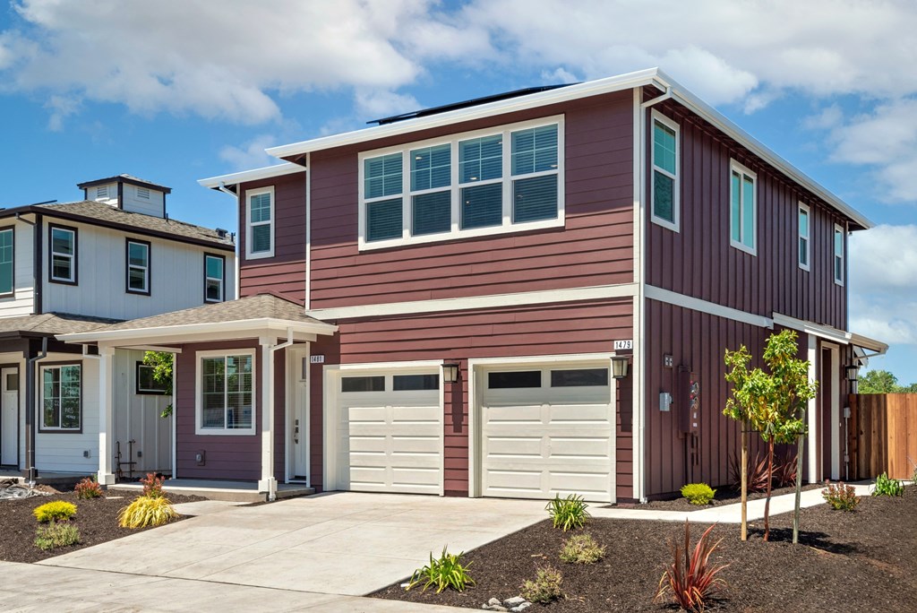 a red house with a garage door in front of it