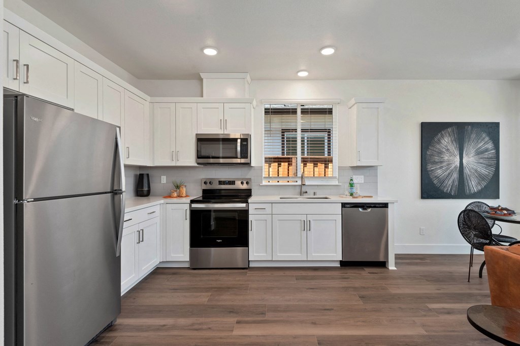 a kitchen with white cabinets and stainless steel appliances