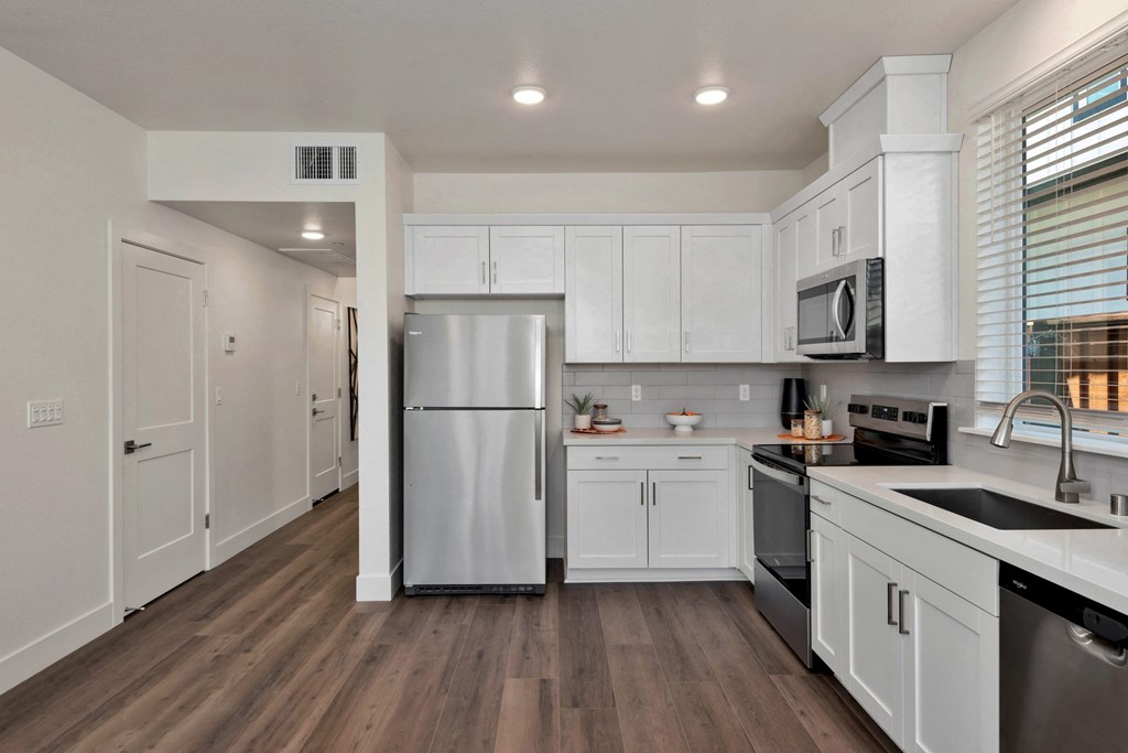 a renovated kitchen with white cabinets and stainless steel appliances
