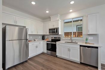 A modern kitchen with stainless steel appliances and white cabinets.