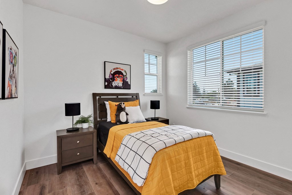 a bedroom with a bed and two windows