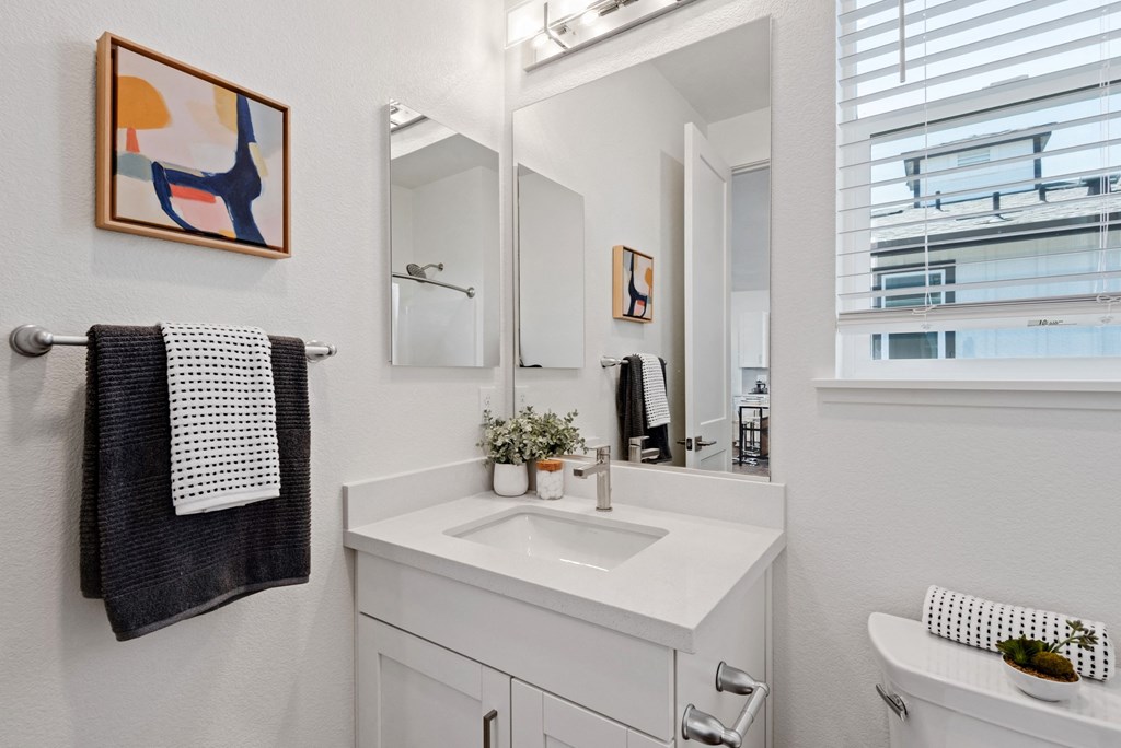 a white bathroom with a sink and a mirror