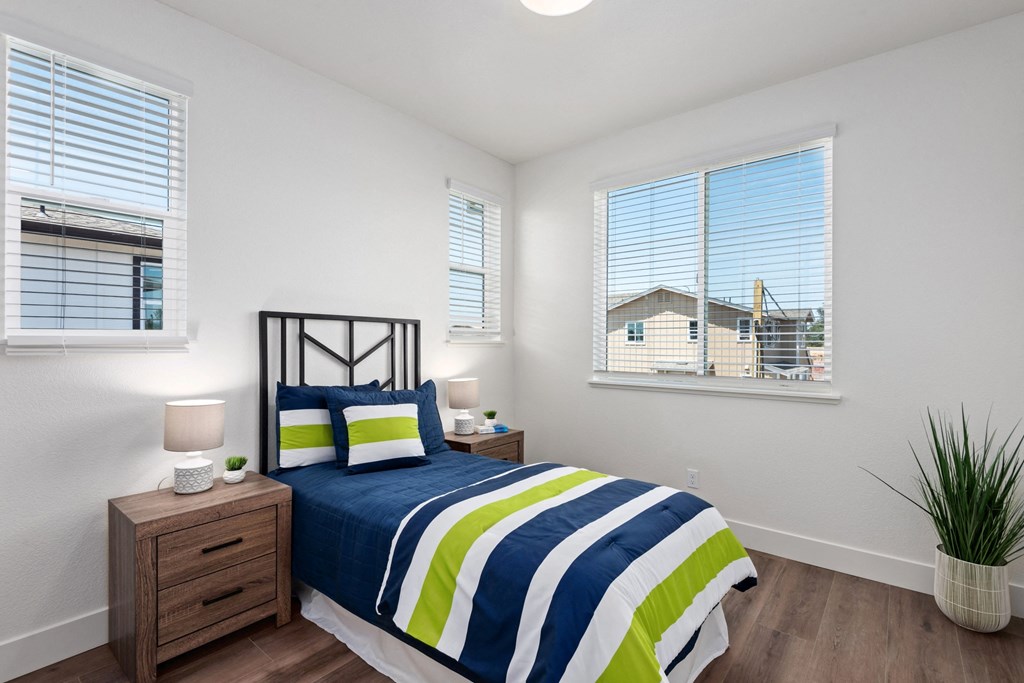 a bedroom with a bed and two windows