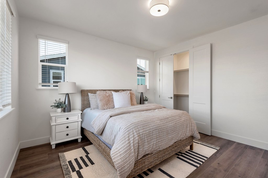 a bedroom with a bed and two windows
