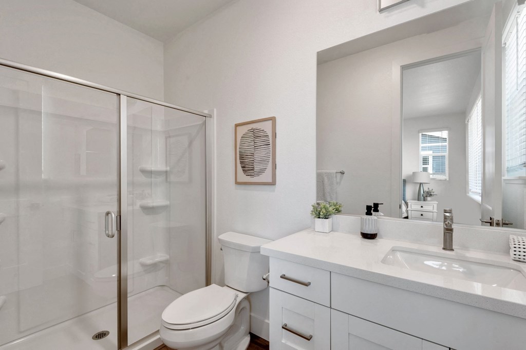 a white bathroom with a shower and a sink