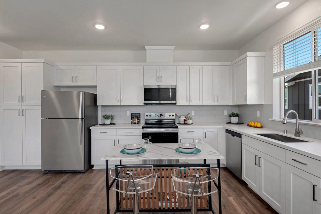 a kitchen with white cabinets and stainless steel appliances