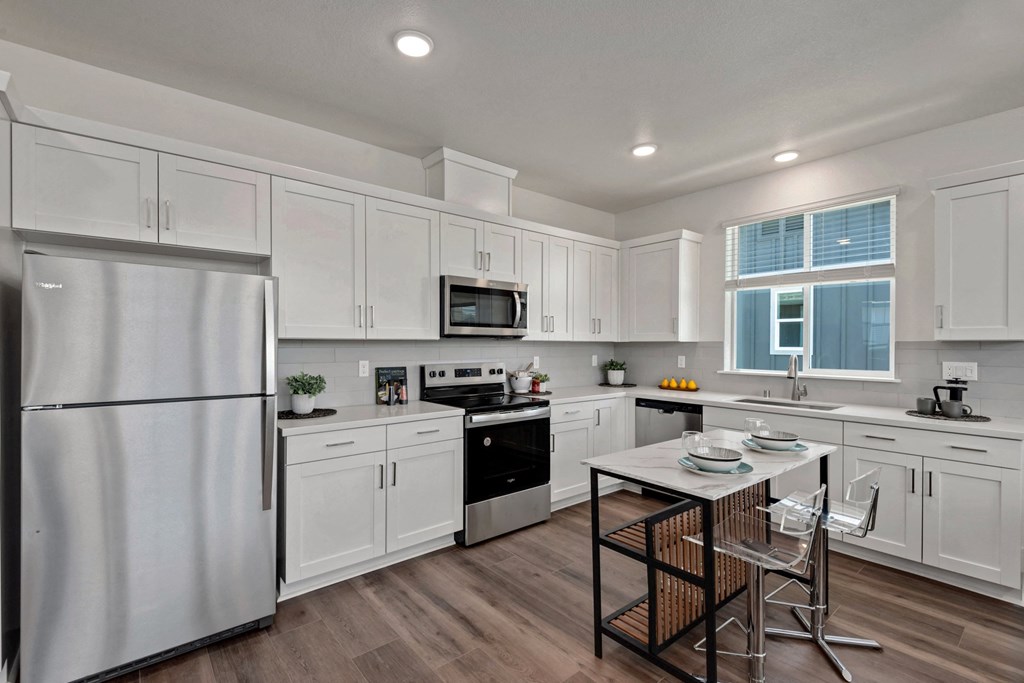 a kitchen with white cabinets and a table with chairs