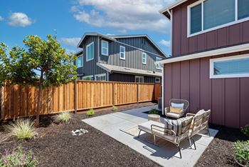 A backyard with a chair and a table.