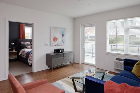 A living room with a blue couch and a red chair.