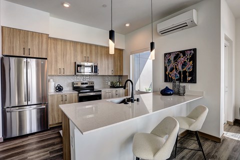 a kitchen with a large island and a stainless steel refrigerator