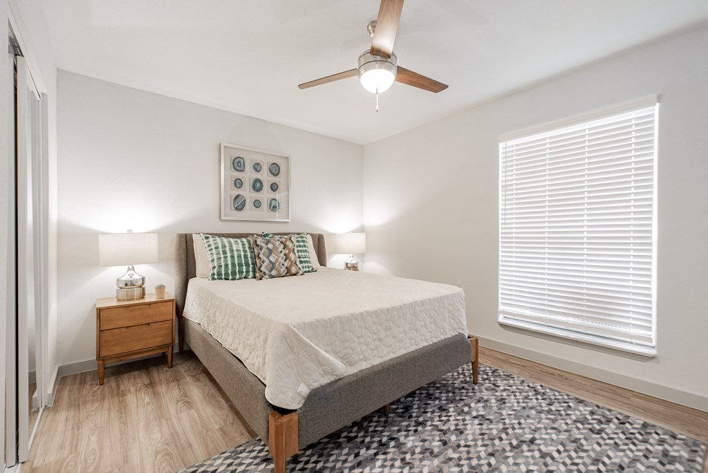 a bedroom with a bed and a ceiling fan