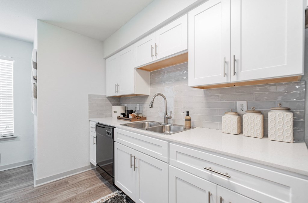 a kitchen with white cabinets and a sink