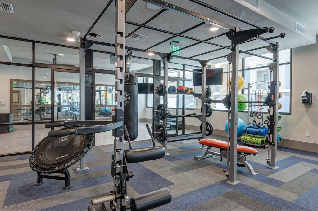 a gym with weights and other equipment in a glass walled room
