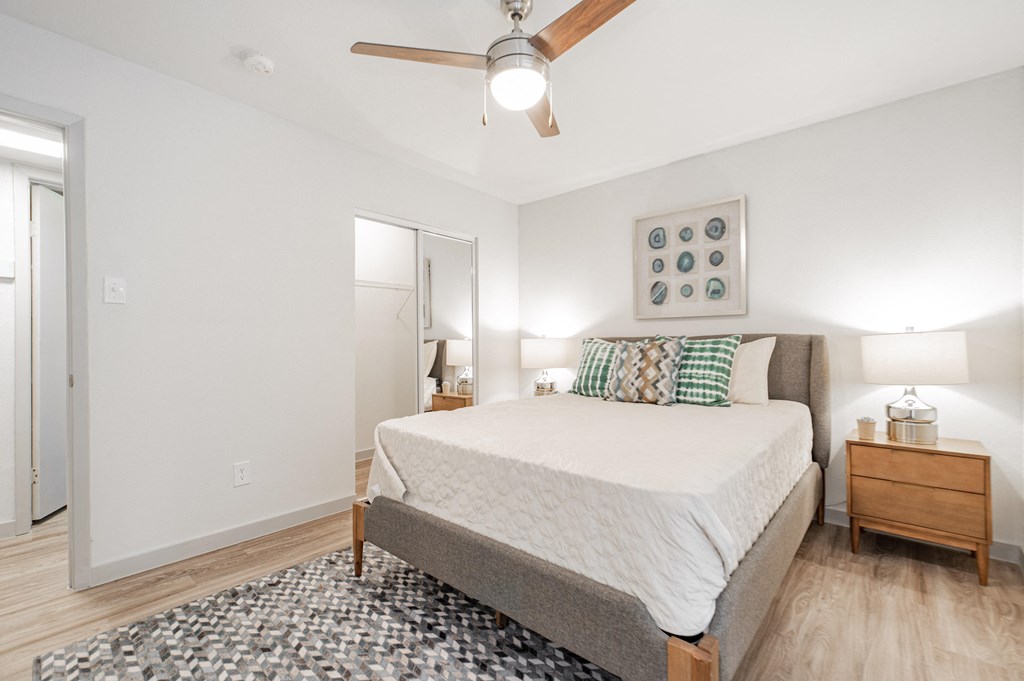 a bedroom with a large bed and a ceiling fan
