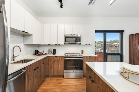 a kitchen with white cabinets and a sink and a window