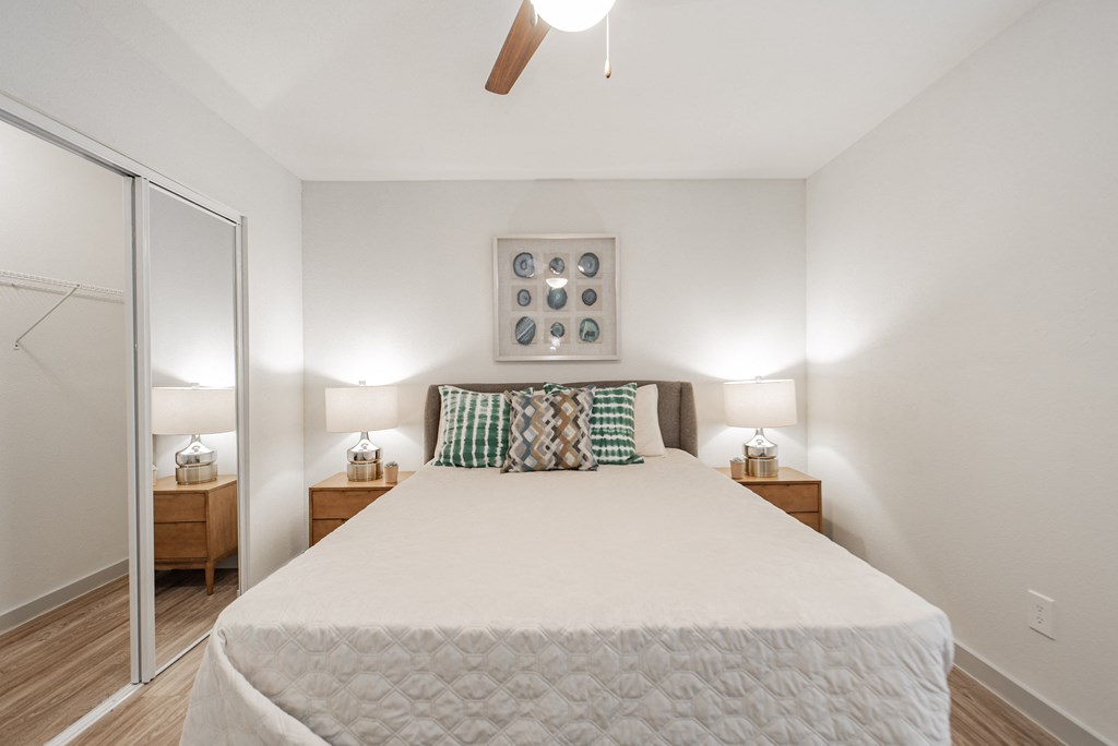 a bedroom with a large bed and a ceiling fan