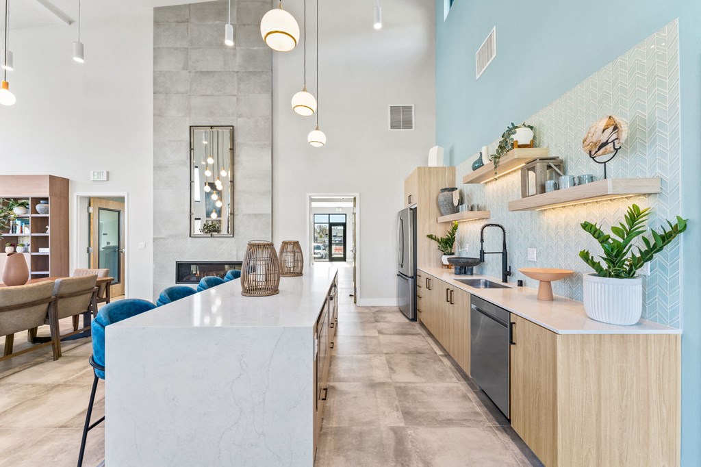 a kitchen with a large island and a living room with a table and chairs