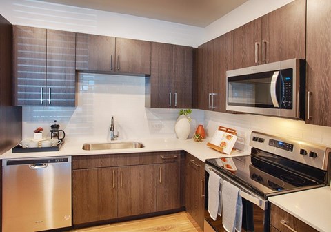 A modern kitchen with wooden cabinets and stainless steel appliances.