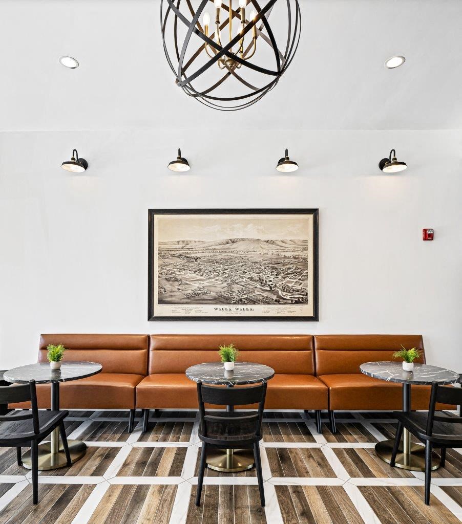 a seating area with couches tables and a picture on the wall