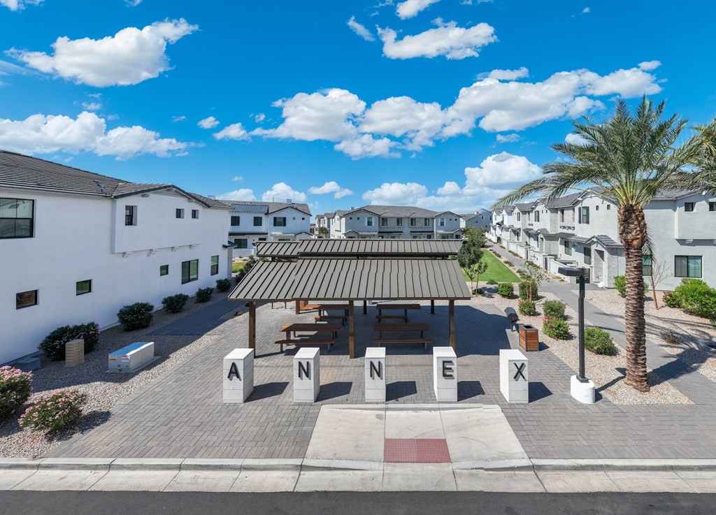 A sunny day at the ANNEX building with a palm tree and a pavilion.