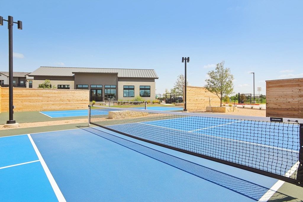 A tennis court with a building in the background.