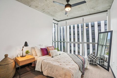 A bedroom with a large bed and a ceiling fan.