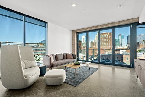 a living room with a view of the city and a couch and a table