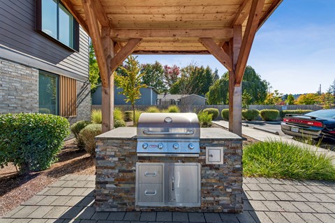 A modern outdoor kitchen with a grill and sink.