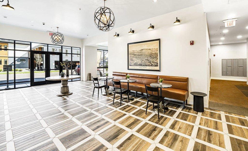 a lobby with a table and chairs and a large window