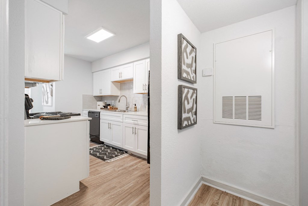 a kitchen with white cabinets and a white door