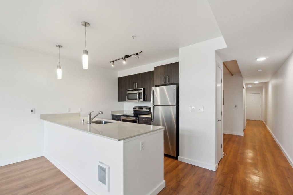 A modern kitchen with a refrigerator, sink, and microwave.