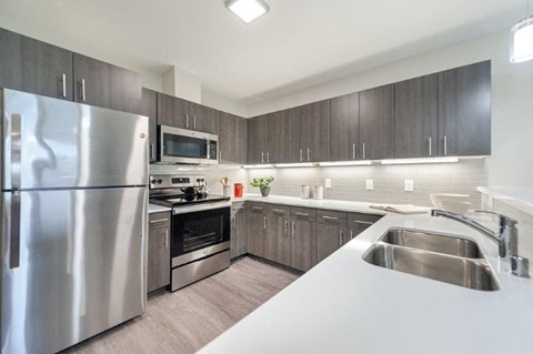 a kitchen with stainless steel appliances and white counter tops