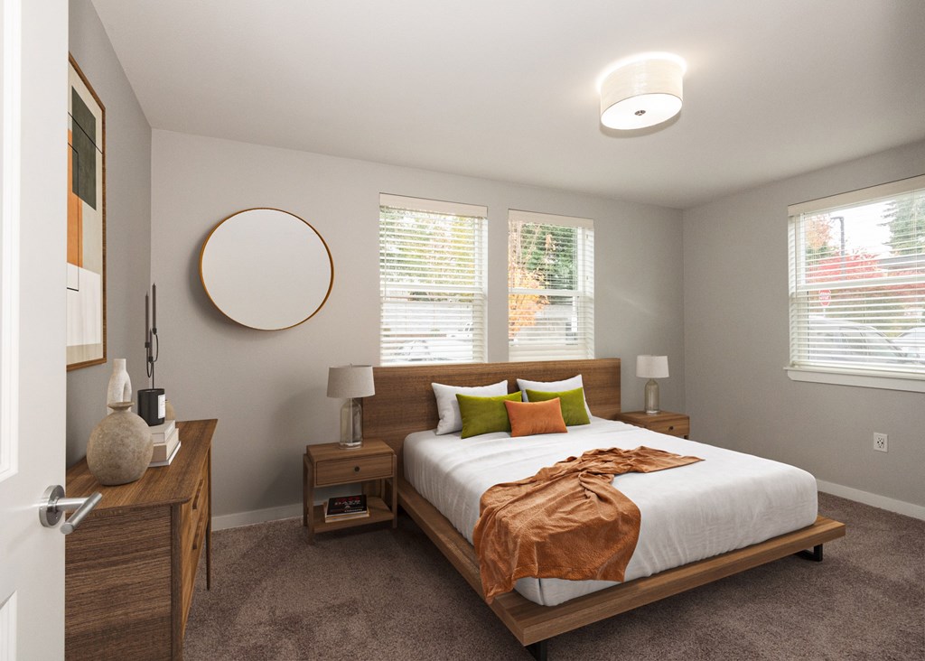 A bedroom with a bed, nightstands, and a round mirror on the wall.