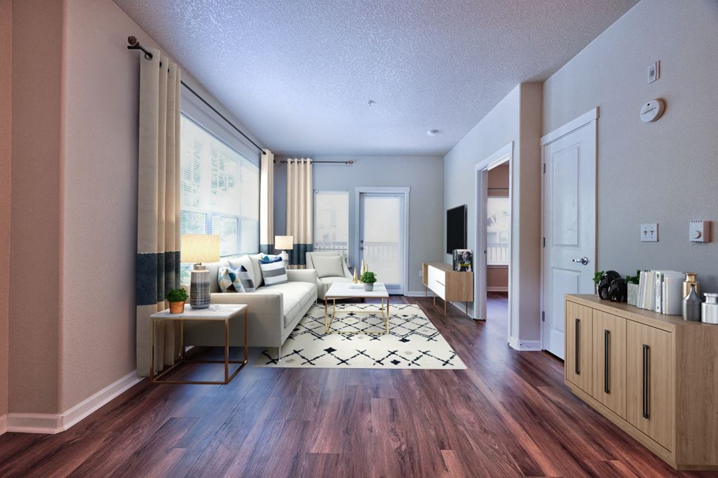 a living room with a white couch and a wooden floor